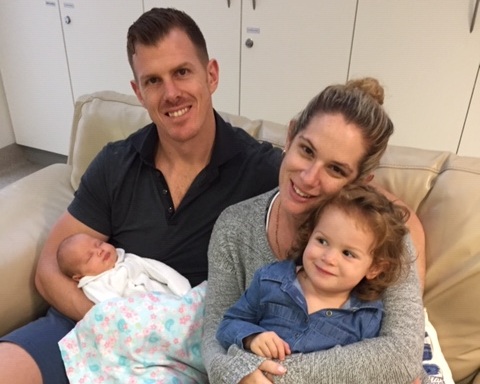 mother and father holding two daughters