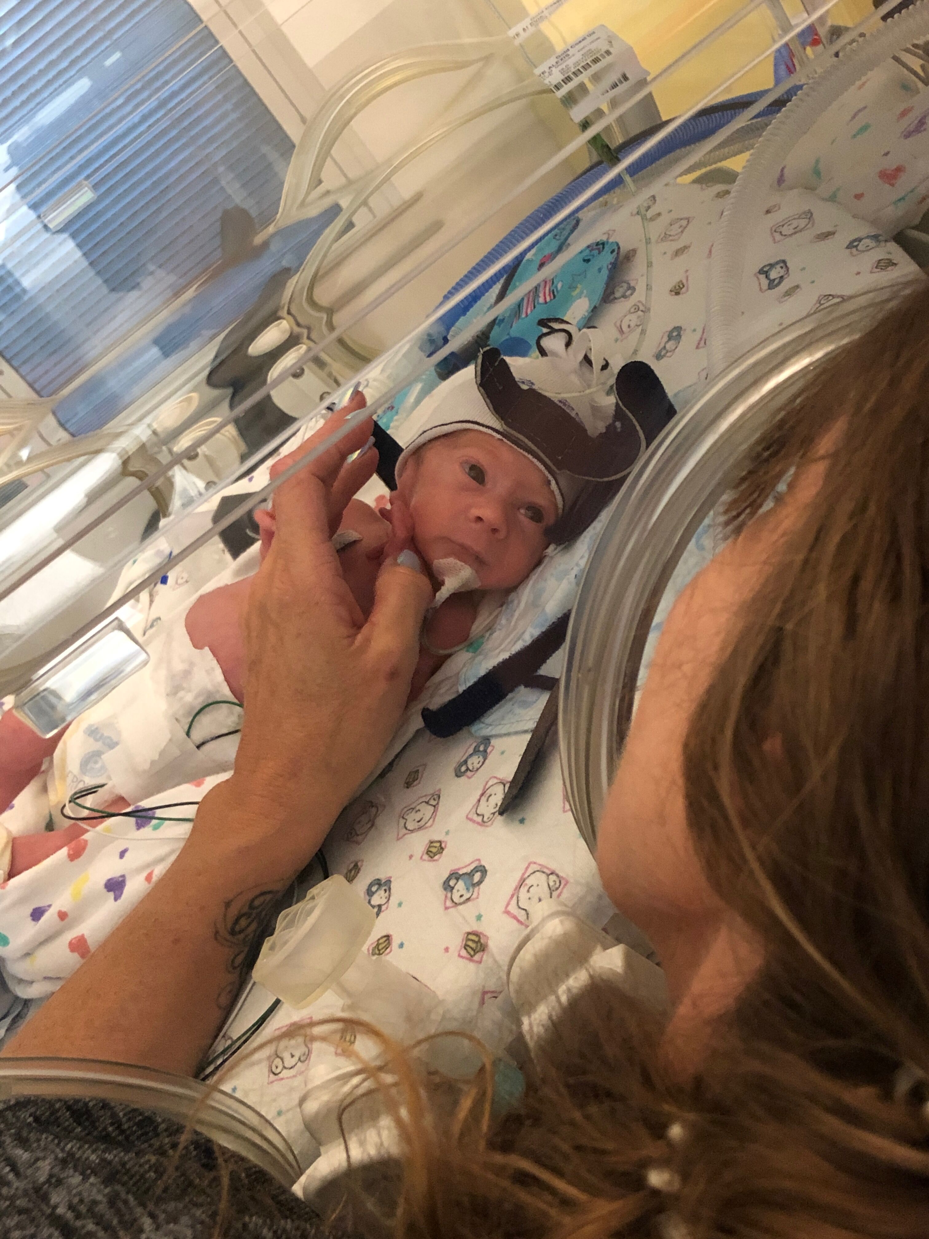 Mother holding newborn son's hand